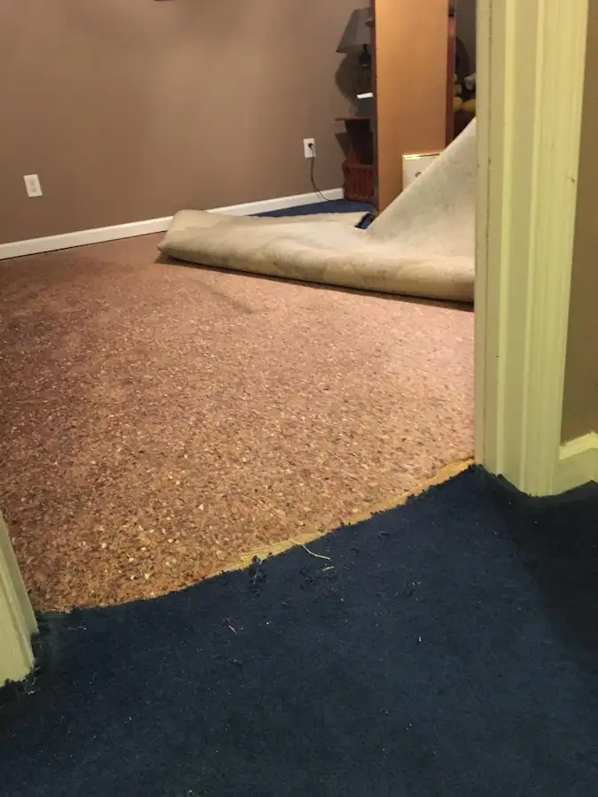 Carpet pad removal revealing water damage during Water Mitigation Services in Tucson